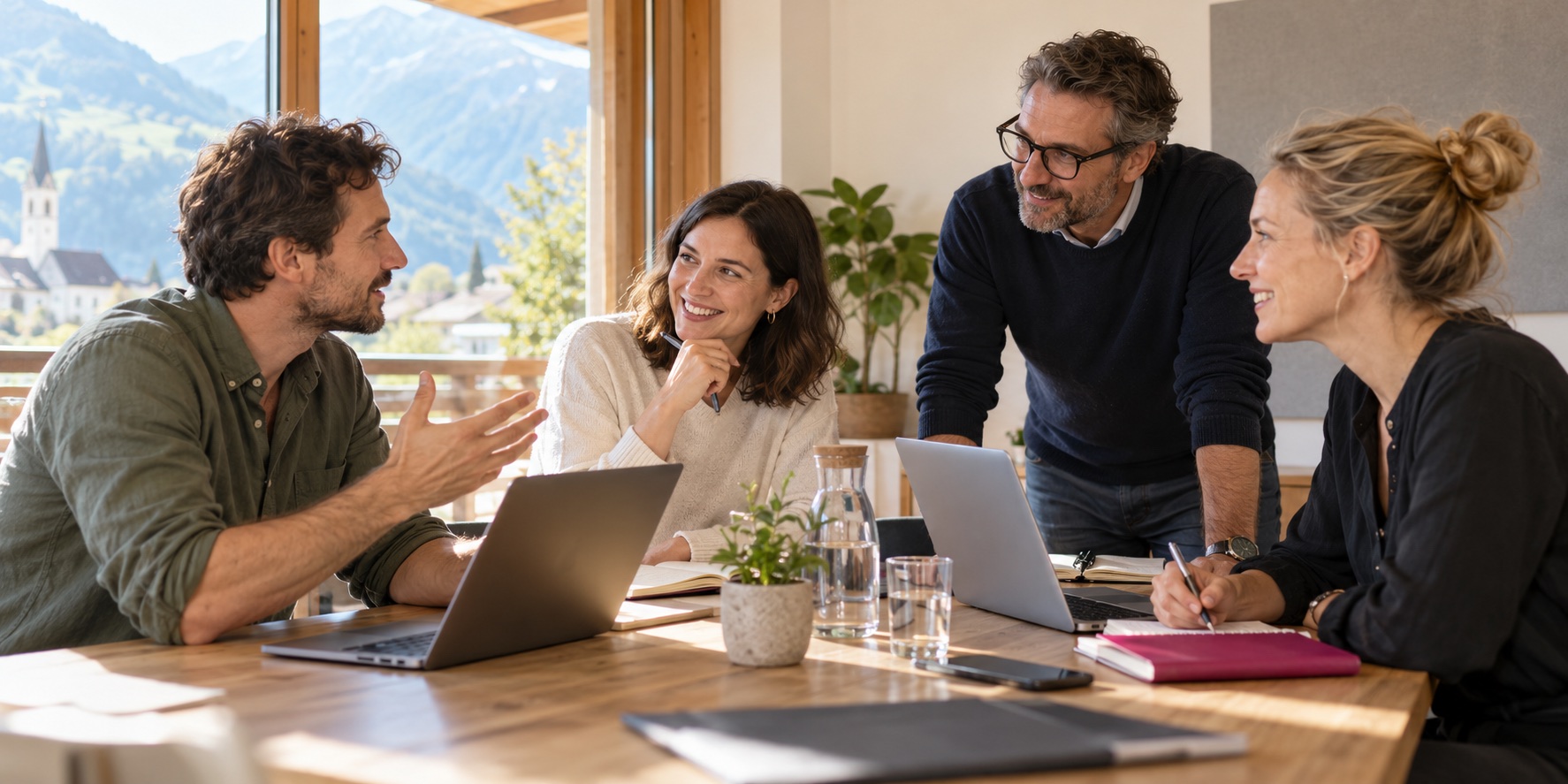 Symbolische Workshop-Szene: Vier Kolleginnen und Kollegen arbeiten gemeinsam mit Laptops.